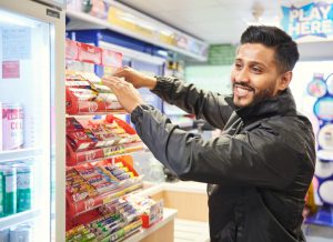 Field representative merchandising a display unit near the checkout